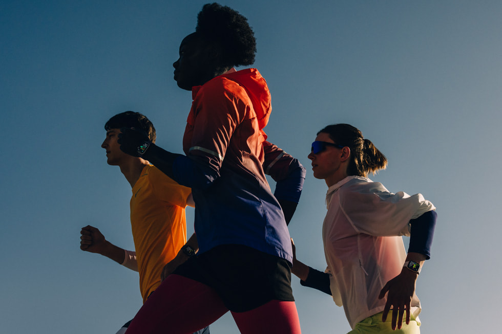 Three people wearing Apple Watch Series 11 run outdoors.